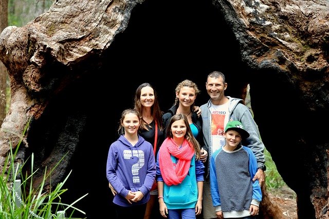 FATHER AND MOTHER ENJOYING HIKING AND WATCHING A CAVE AT THE WEEKEND.