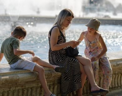 A MOTHER ENJOYING WITH HER CHILDREN ON A RIVER SIDE