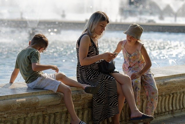 A MOTHER ENJOYING WITH HER CHILDREN ON A RIVER SIDE