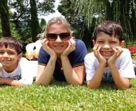 A MOTHER ENJOYING IN THE GARDEN WITH HER CHILDREN AS A HAPPIER FAMILY AFTER ADOPTING CHELSEA ACTON FAMOUS PARENTING STRATEGIES.