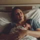 A mother in the hospital after giving birth to a baby.