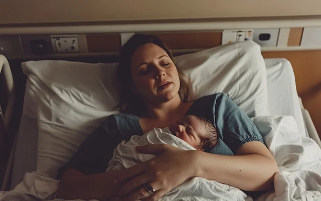 A mother in the hospital after giving birth to a baby.