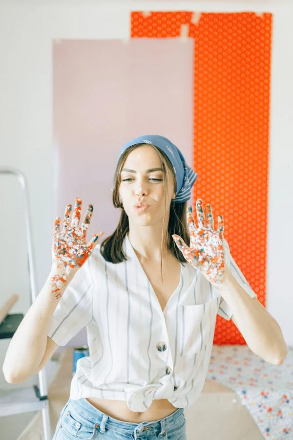 A WOMAN DOING ART WORK AT THE WALLS OF HER HOME