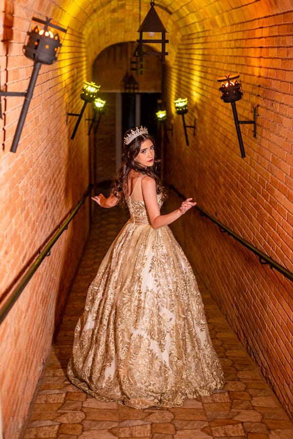 A WOMAN PASSING THROUGH A PASSAGE WHERE RECESSED LIGHTING CASING GLOWING