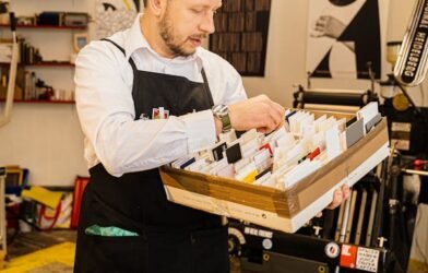 A MAN IS WORKING ON HIS PRINTING MACHINE