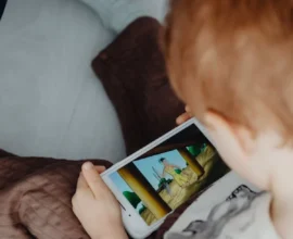 A SMALL KID WATCHING MOBIE