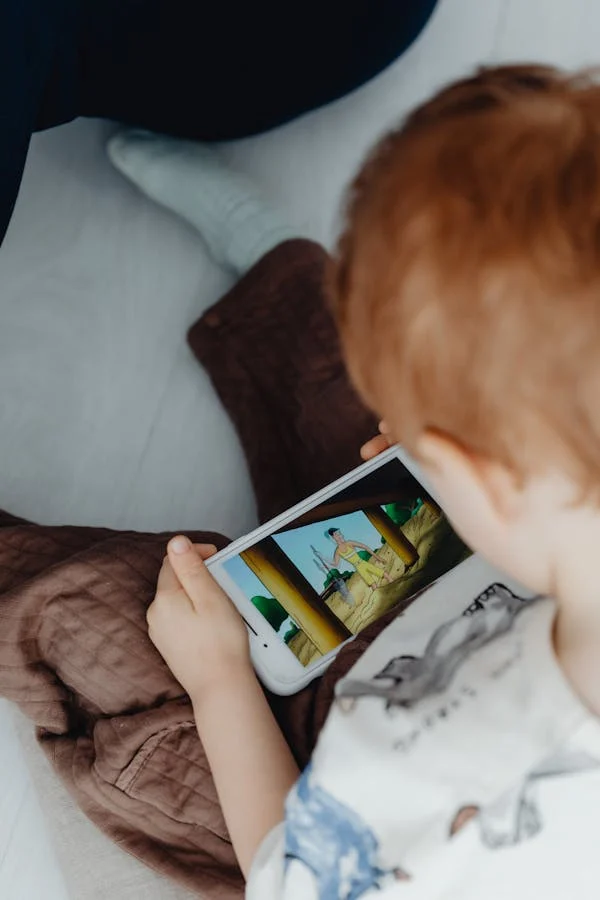 A SMALL KID WATCHING MOBIE