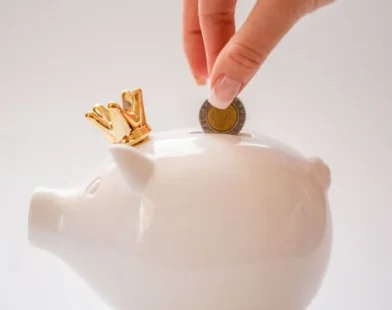 A PERSON SAVING MONEY IN MONEY BOX